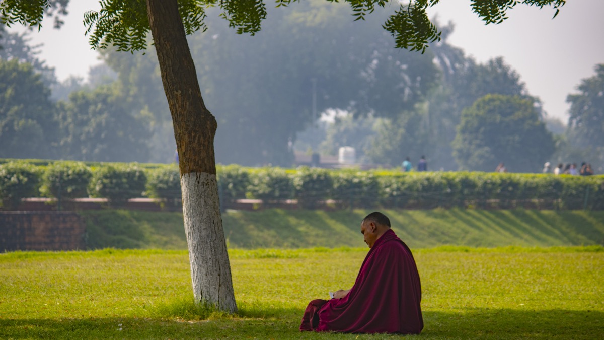 Ein buddhistischer Mönch, der in tiefer Meditation unter einem Baum sitzt, völlig still