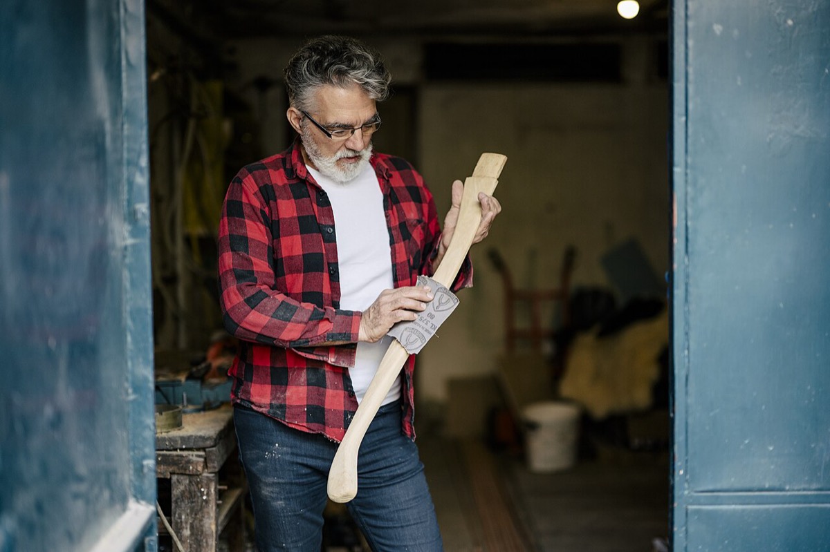 Craftsman shaping a wooden piece in a workshop by daylight: building is boring from the outside, the same actions repeated day after day without applause