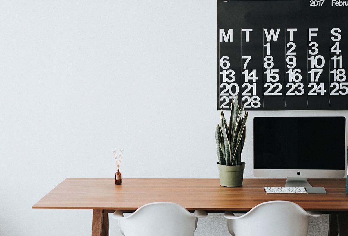 A tidy wooden desk with a lamp and notebook: decluttered workspace is a direct input into mental clarity