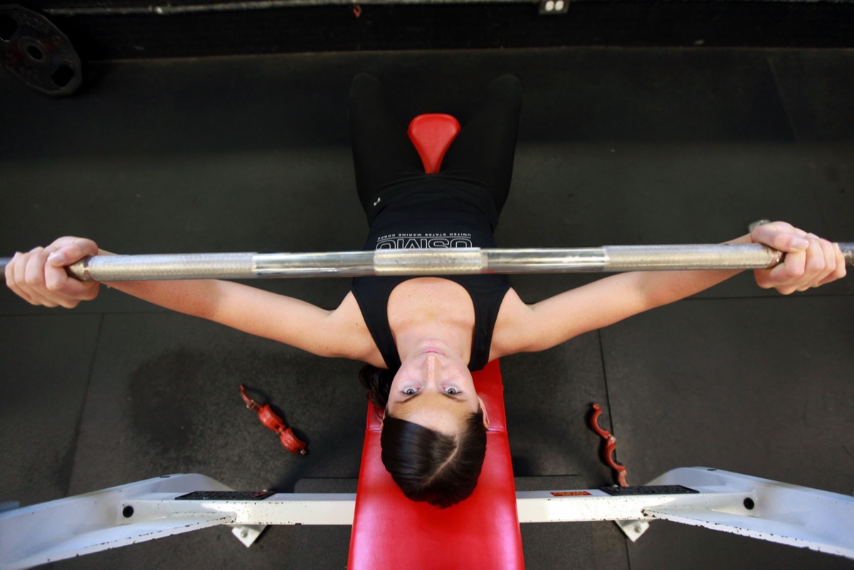 Athlete training with weights in a gym: daily earning is the practice that prevents complacency from becoming decay
