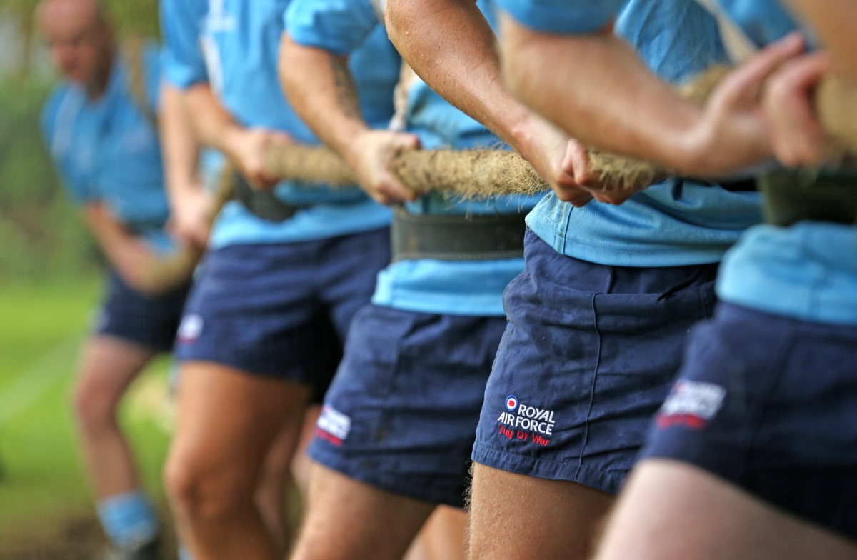 RAF tug of war team straining together during training, eight athletes pulling in unison against visible resistance