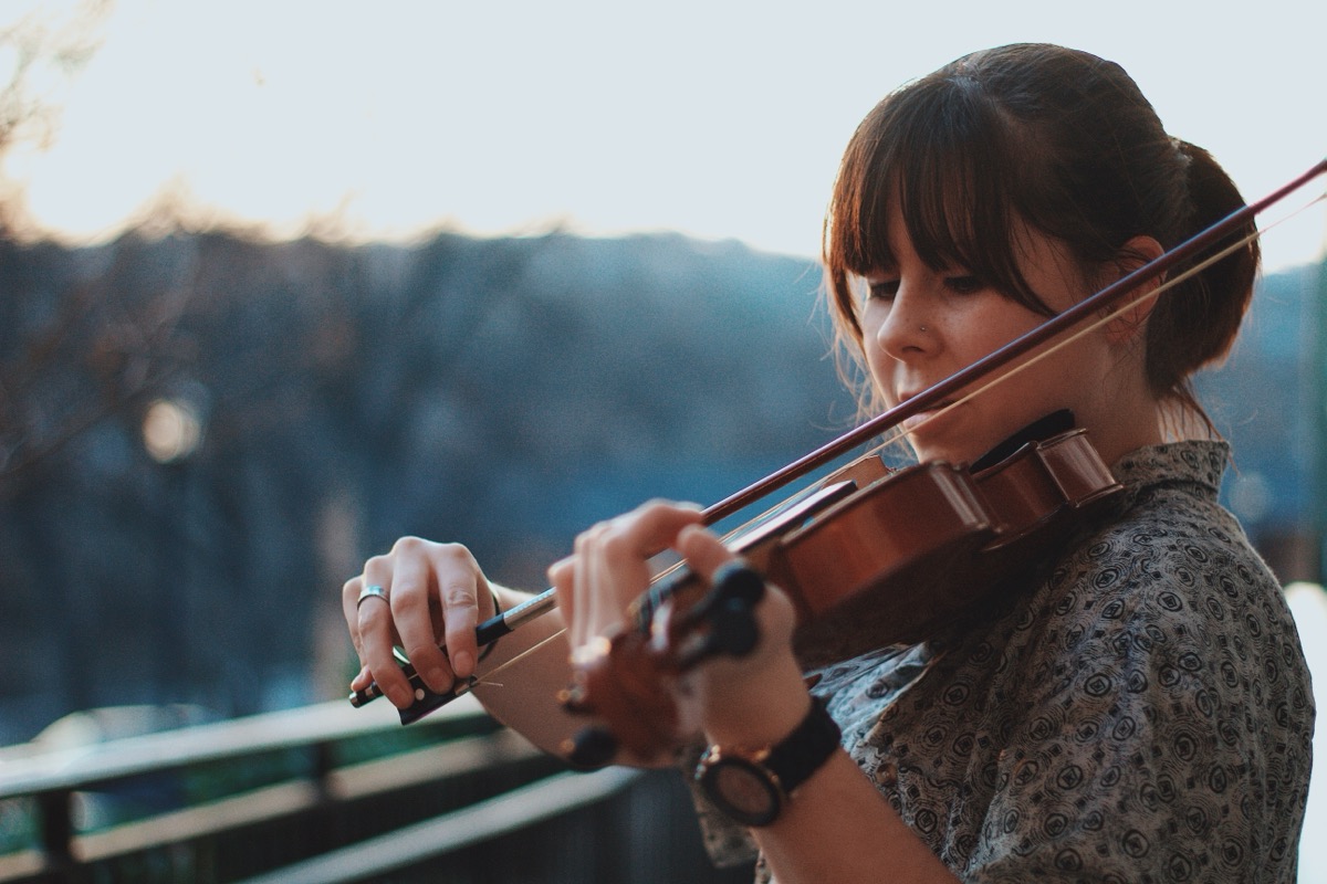A violinist practicing outdoors: repetition at the edge of ability over years is what the research describes
