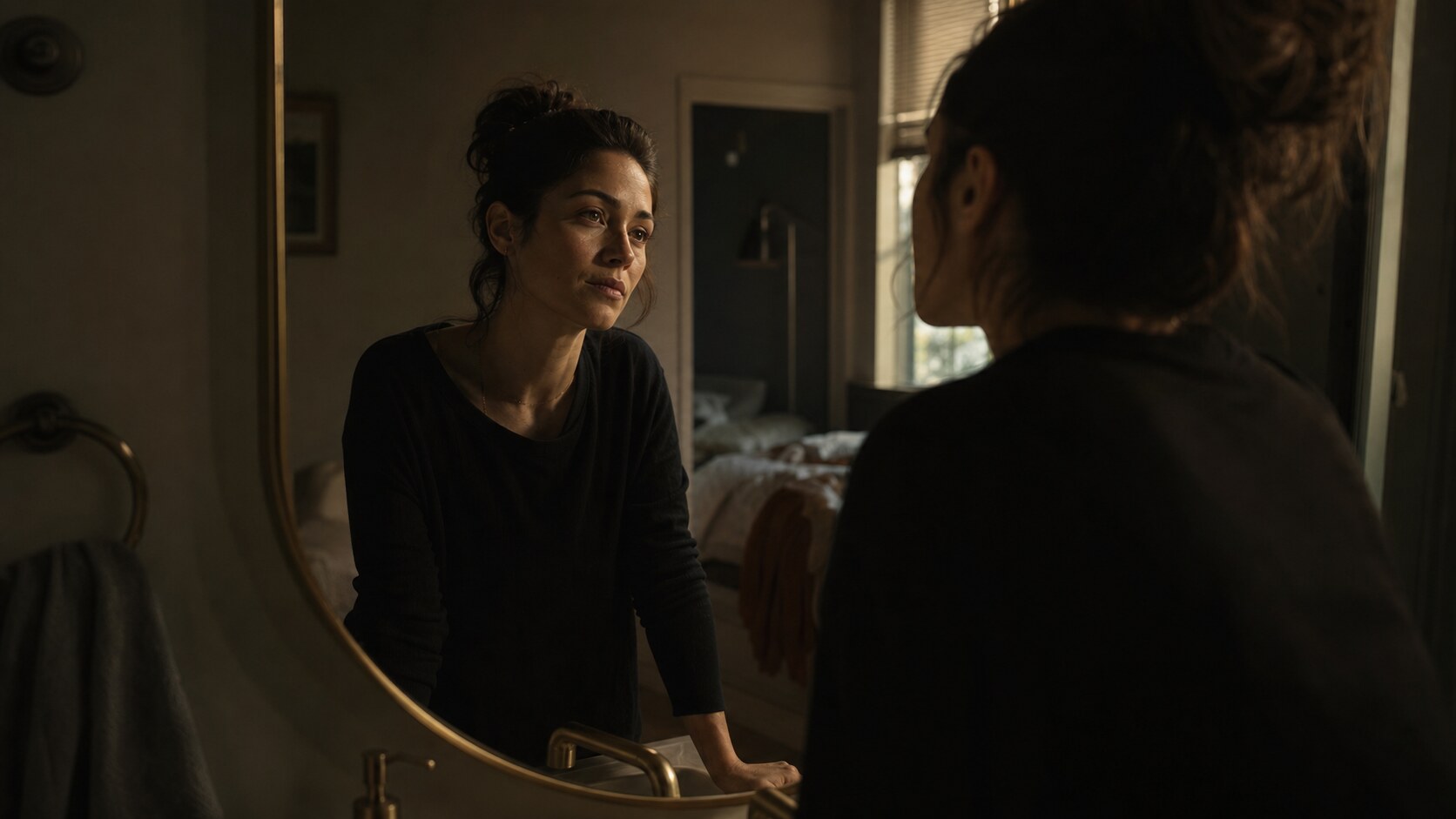 A mother looking at herself in a mirror with quiet resolve