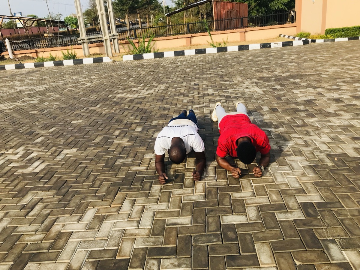 Person doing push-ups on the ground, focused and mid-rep