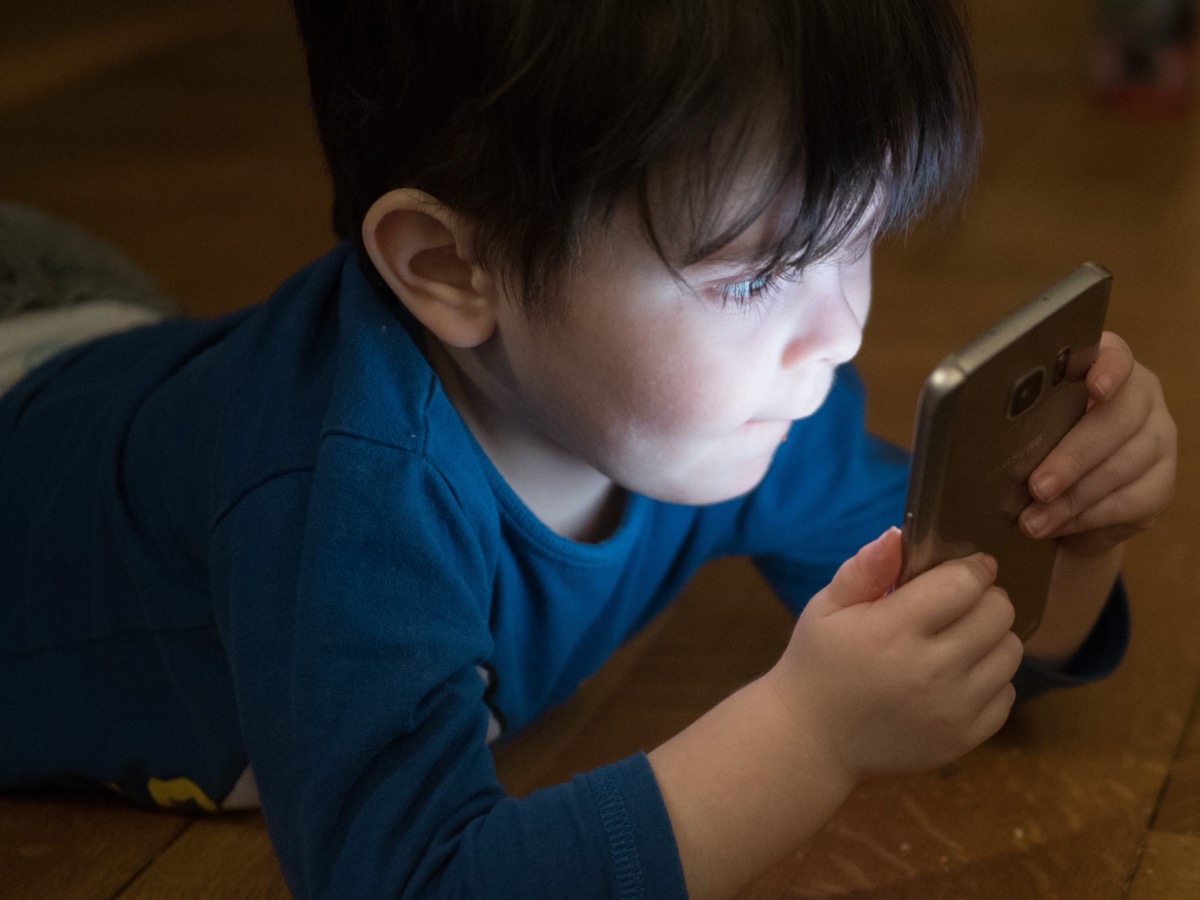 A young person staring into a phone screen: the device is not evil, it is just engineered to never let you look away