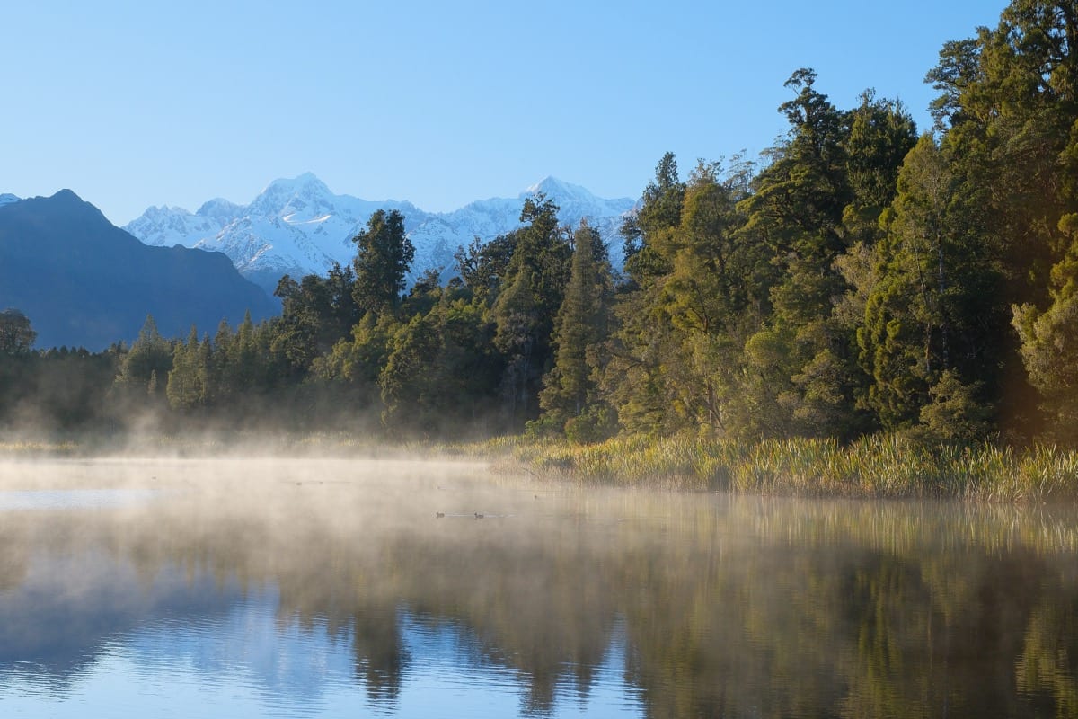 A still lake reflecting mountains: sufficiency is the quiet base that makes everything else possible
