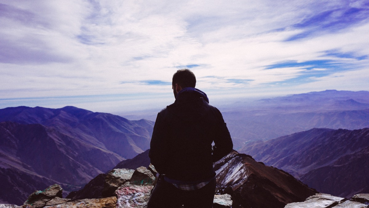 Person standing on a mountaintop: sufficiency is the soil that makes the climb sustainable